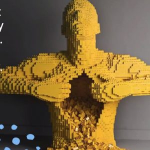 Yellow superhero made from lego opening his shirt