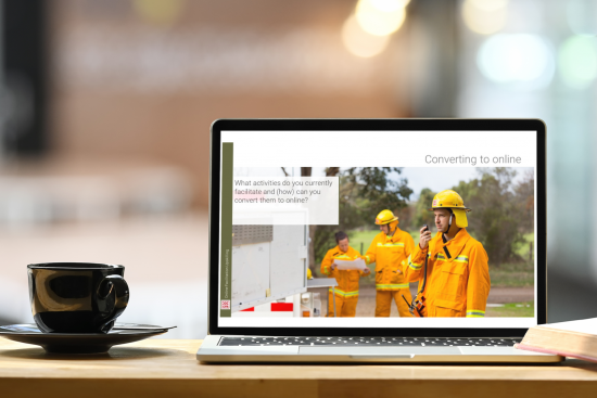 Laptop with firefighters on screen placed on a desk with a cup