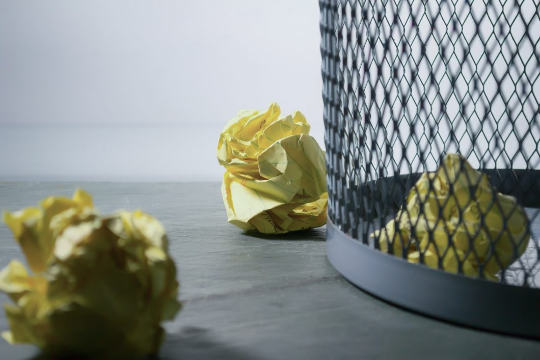 mesh bin with crumpled yellow paper balls next to it
