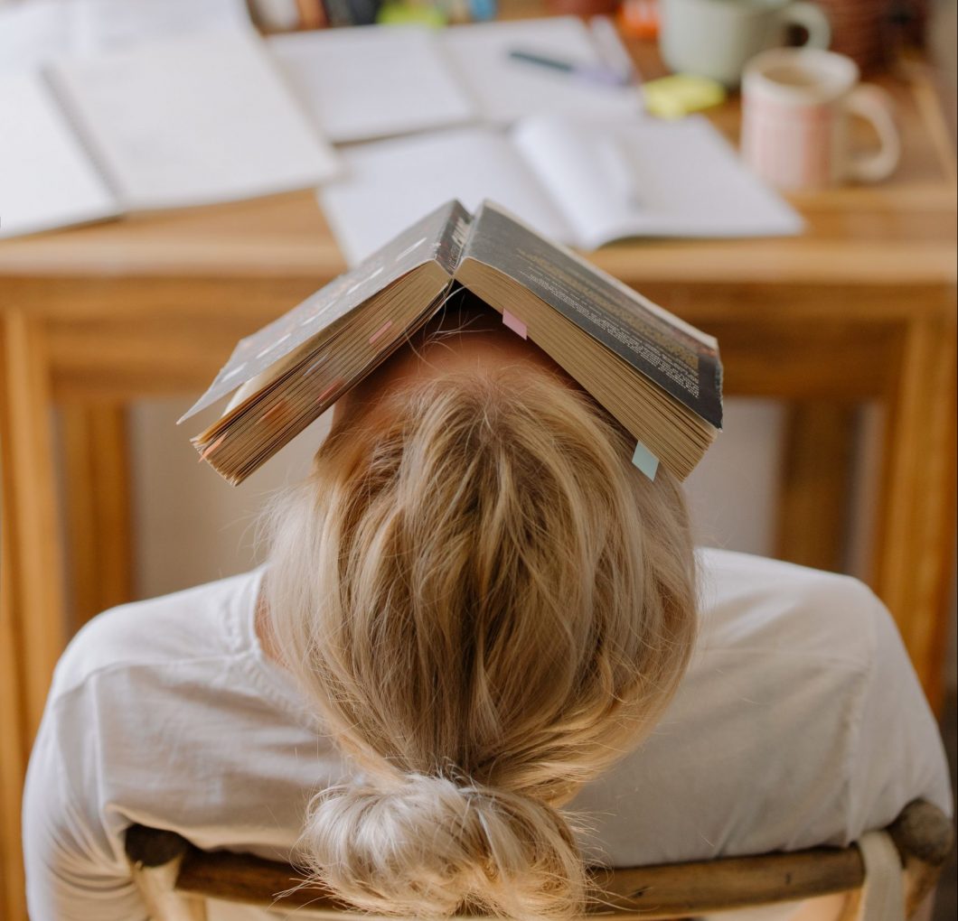 studying woman with book on her head